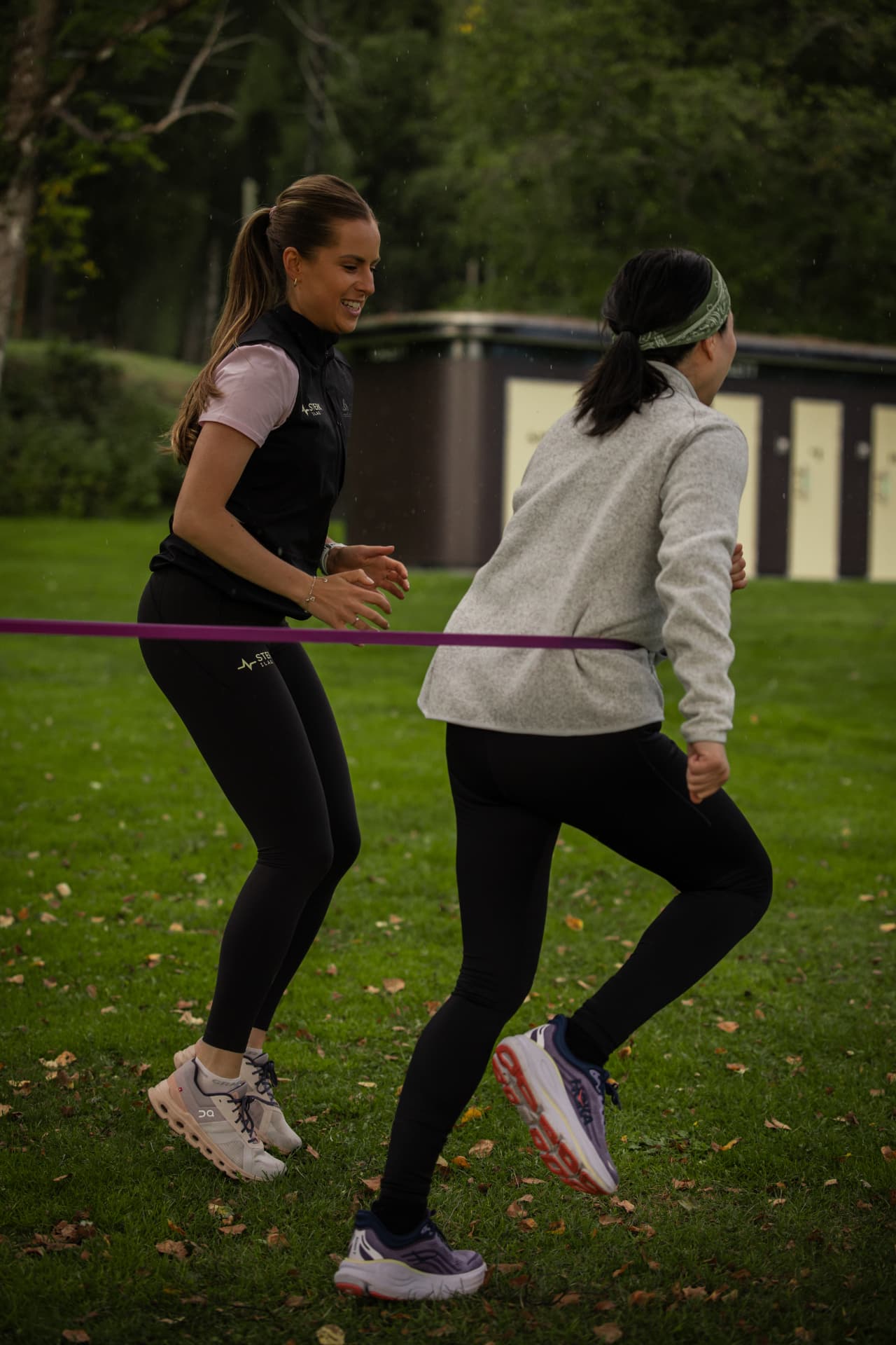 To deltakere trener med strikk på plenen ved Bogstad